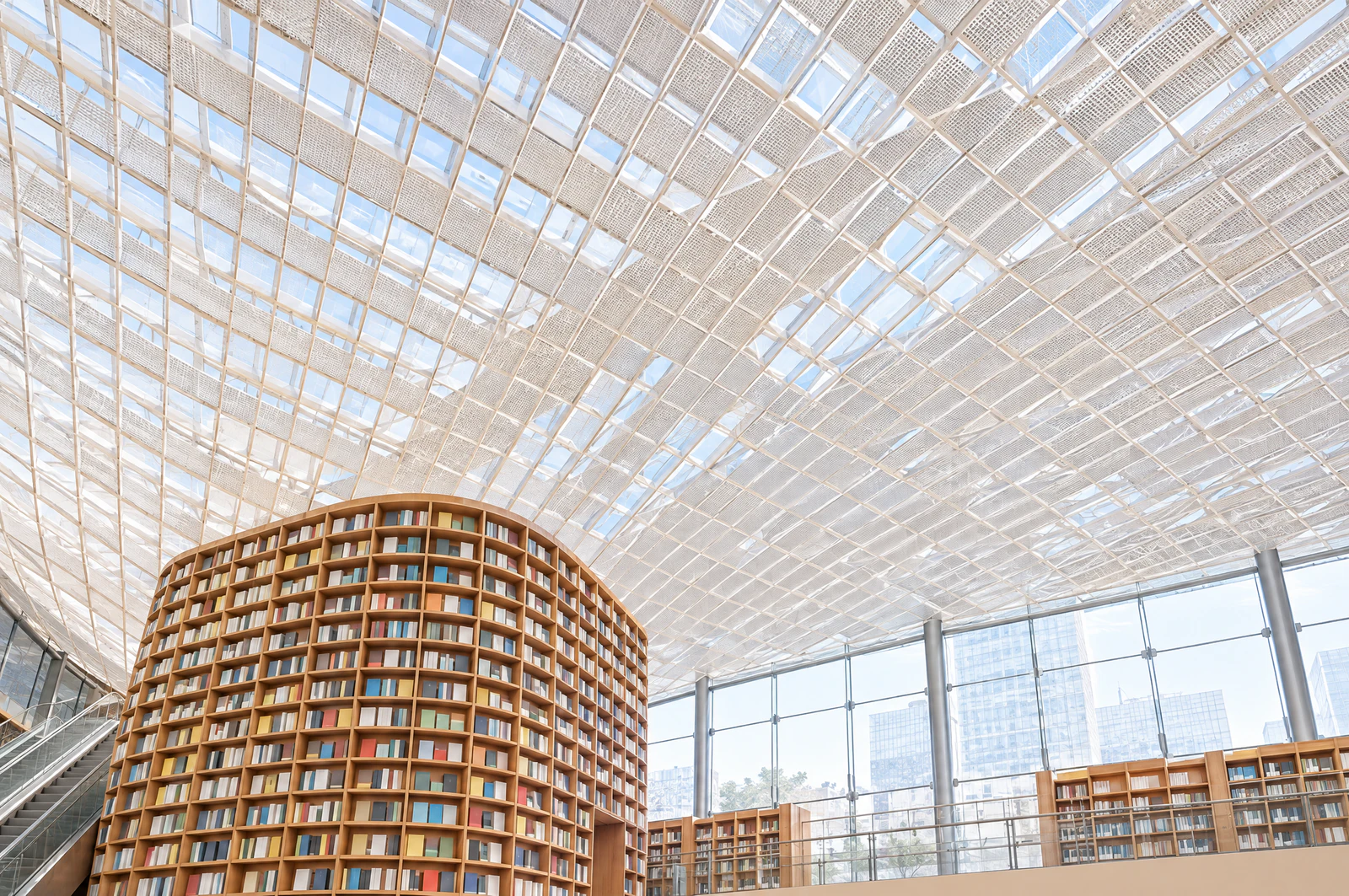 Looking up at a white lattice ceiling and windows above tall wooden bookshelves. No people. Editorial image.